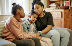 A mother having a serious conversation with her two daughters, focusing on helping children cope with divorce.