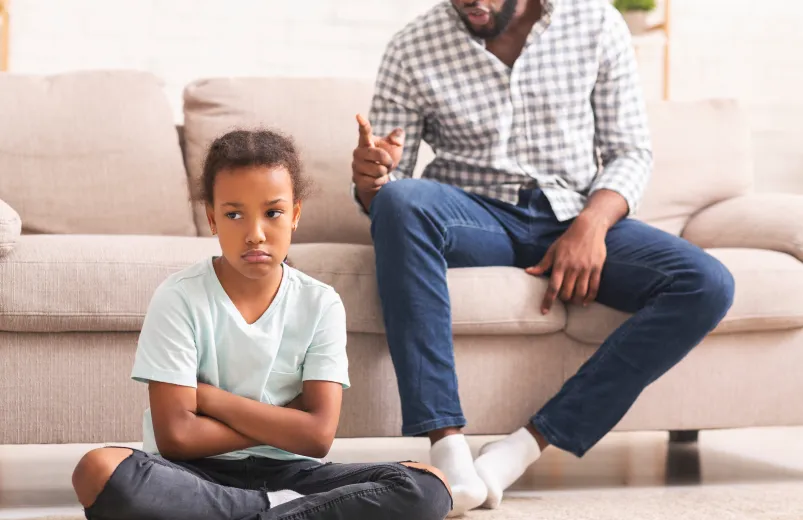 Father scolding daughter for bad behavior at home.
