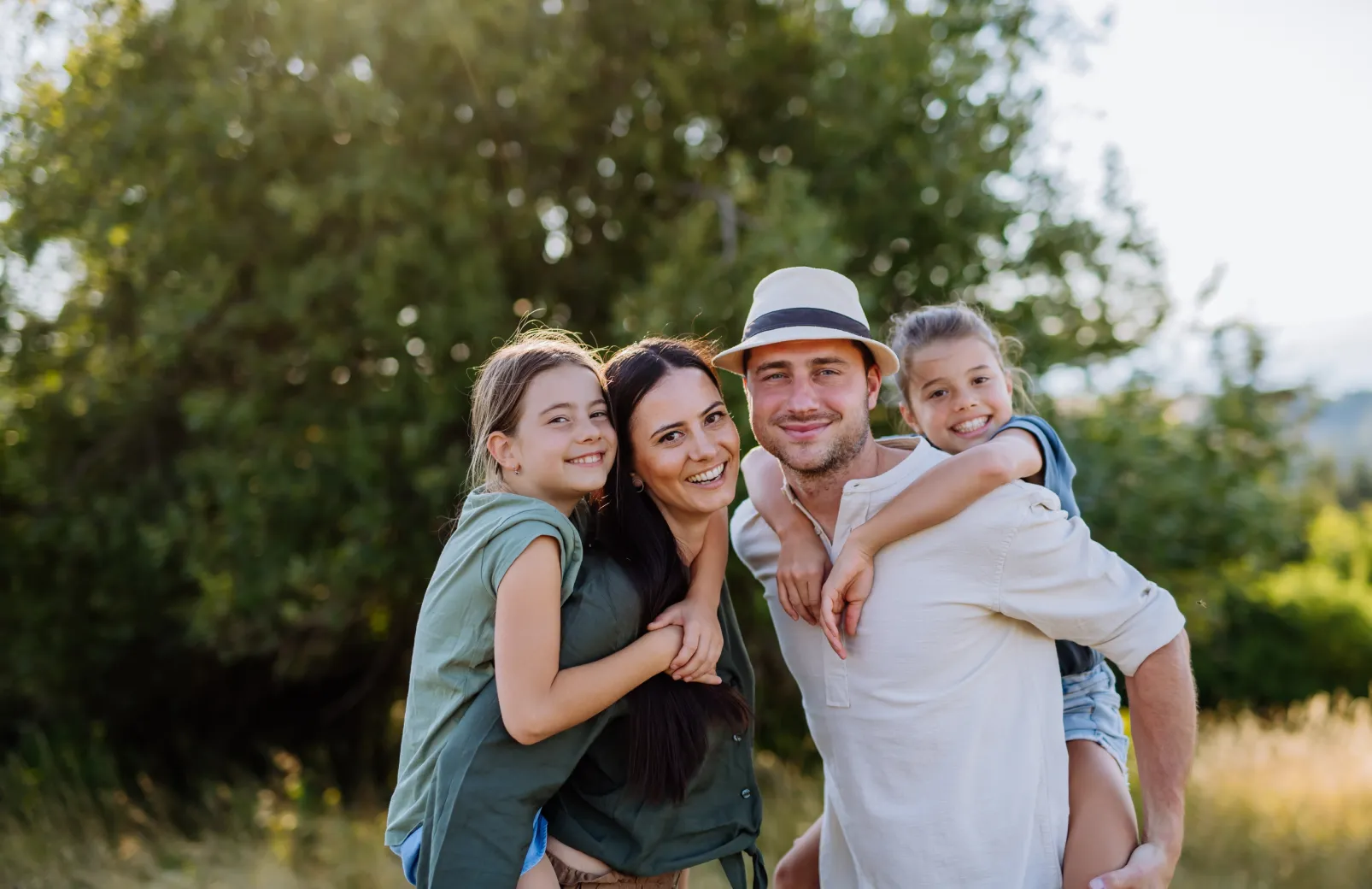 Family enjoying time together outdoors, smiling and embracing.