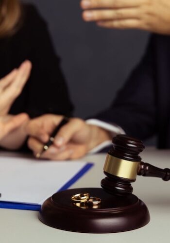 A gavel and two opposing hands raised to each other symbolize the struggle and legal battles of a high-conflict divorce